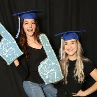 two friends taking GradFest photos with foam fingers